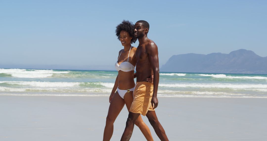 Happy Couple Walking on Sunny Beach in Swimwear - Free Images, Stock Photos and Pictures on Pikwizard.com