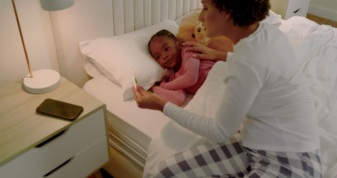 Mother Checking Sick Daughter's Temperature in Bedtime Procedure