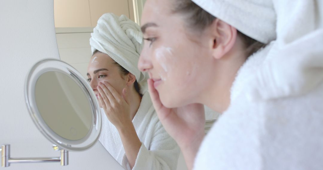 Woman Applying Cream in Bathroom Smiling in the Mirror - Free Images, Stock Photos and Pictures on Pikwizard.com