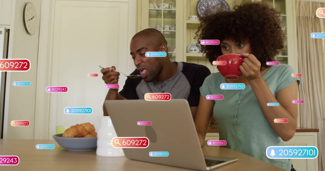 Couple Enjoying Breakfast with Laptop Notifications in Kitchen