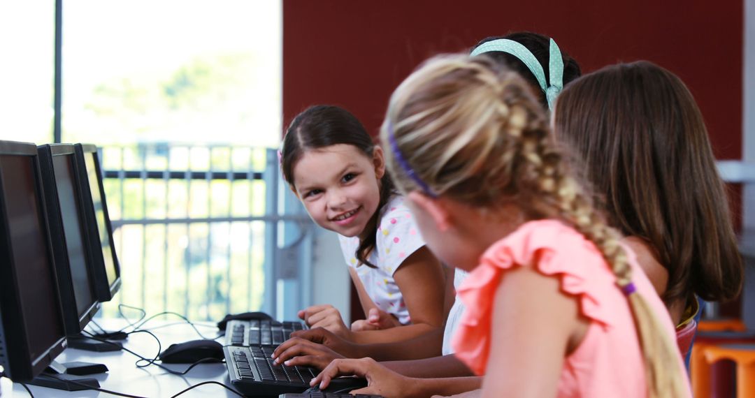 Schoolgirls Laughing Together Working on Classroom Computers