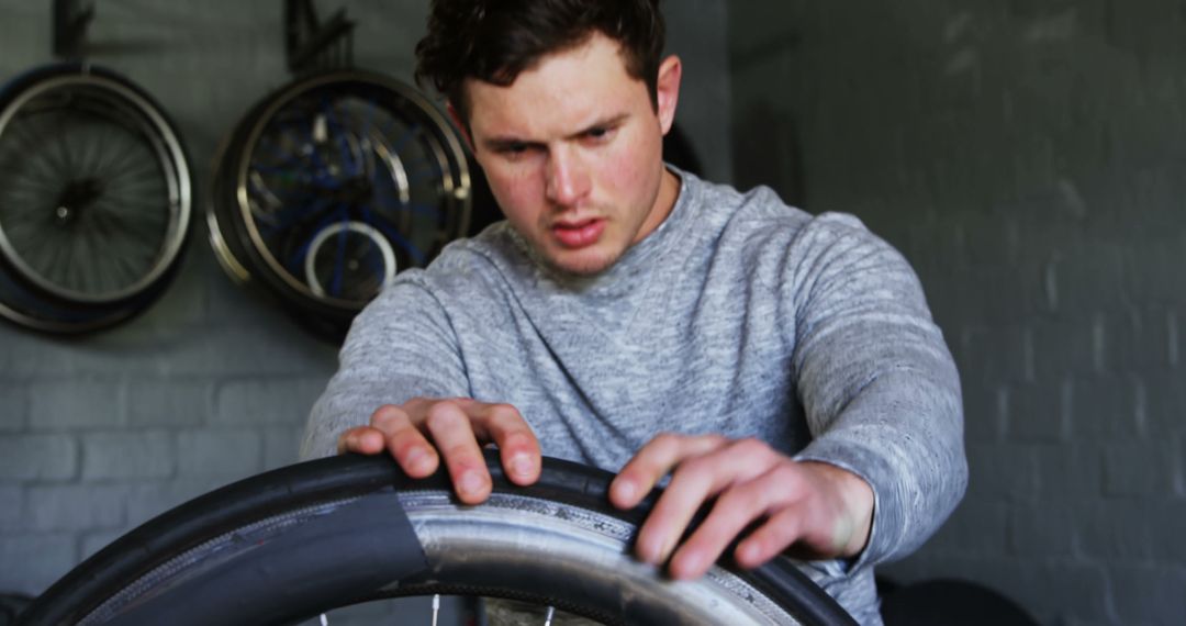 Focused Man Repairing Bicycle Tire in Workshop - Free Images, Stock Photos and Pictures on Pikwizard.com