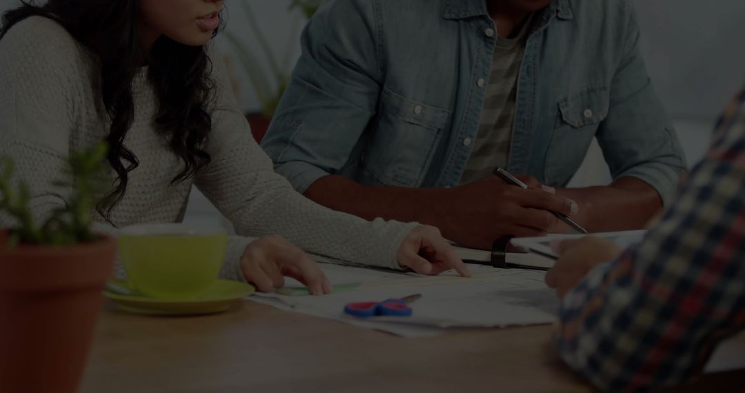 Office Team Collaborating over Documents at Modern Workspace Table