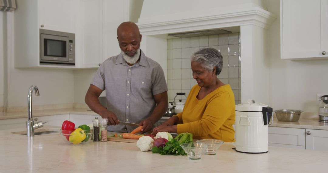 African american senior couple chopping vegetables together in the kitchen at home - Free Images, Stock Photos and Pictures on Pikwizard.com