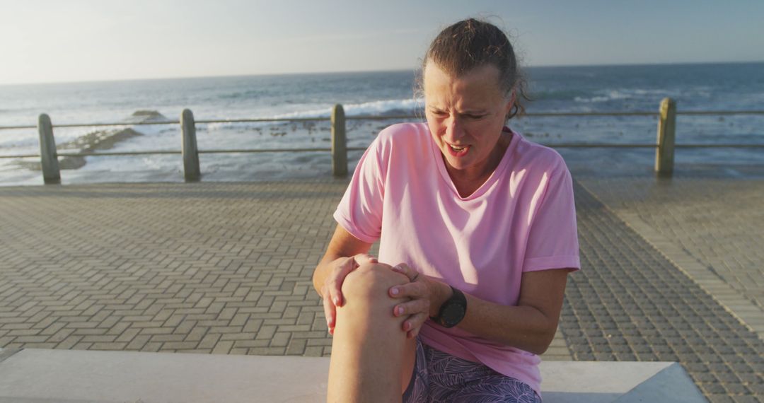 Senior Woman Resting with Knee Pain Near Sea - Free Images, Stock Photos and Pictures on Pikwizard.com