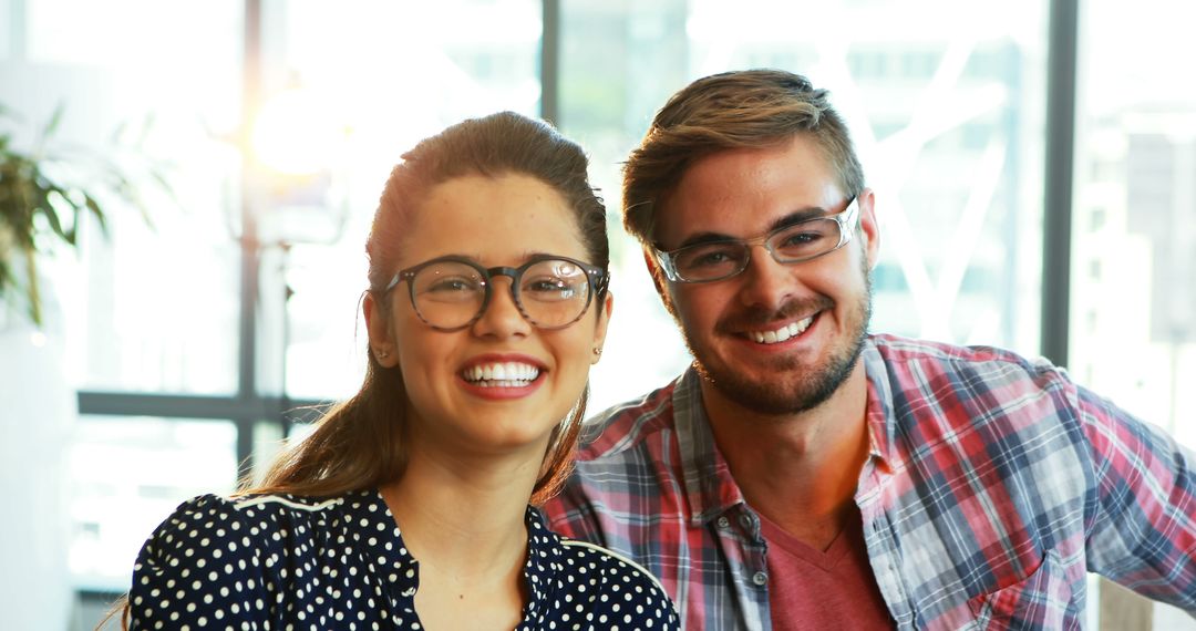 Smiling Young Professionals with Glasses in Modern Office - Free Images, Stock Photos and Pictures on Pikwizard.com