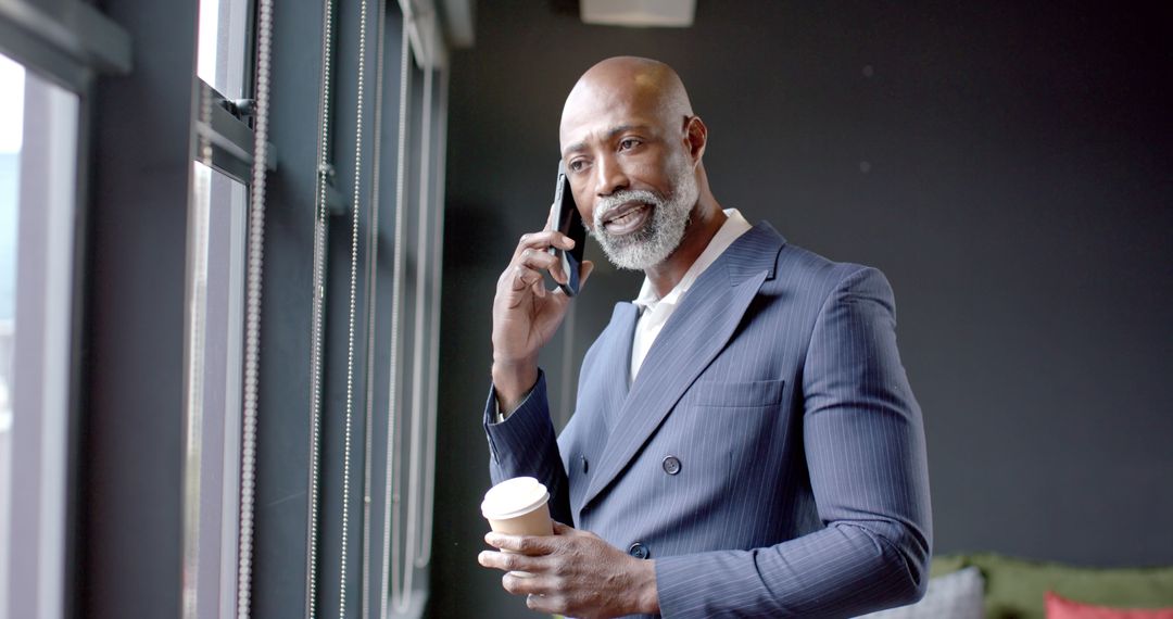 Confident Businessman Talking on Phone While Holding Coffee Cup - Free Images, Stock Photos and Pictures on Pikwizard.com