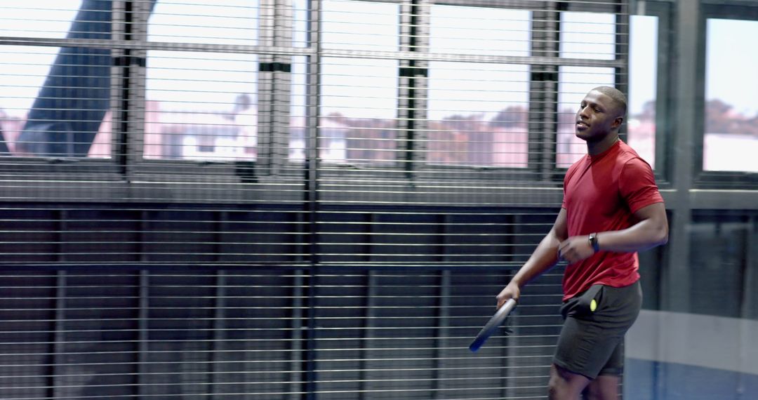 Strong Athlete Holding Padel Racket in Indoor Court Context