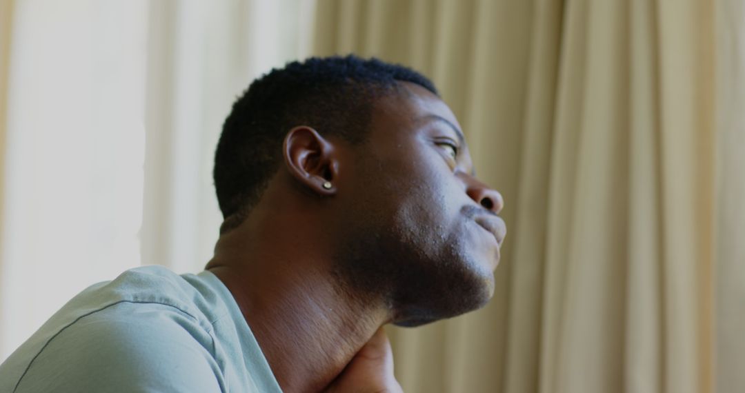 Thoughtful Man Gazing Out Window in Gentle Light