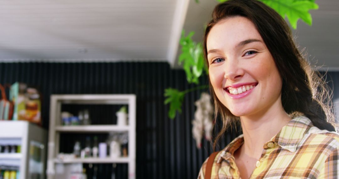 Smiling Woman in Coffee Shop with Plant in Background - Free Images, Stock Photos and Pictures on Pikwizard.com