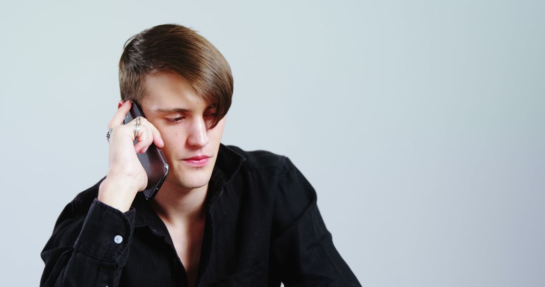 Young Man Concentrating While Talking on Phone - Free Images, Stock Photos and Pictures on Pikwizard.com