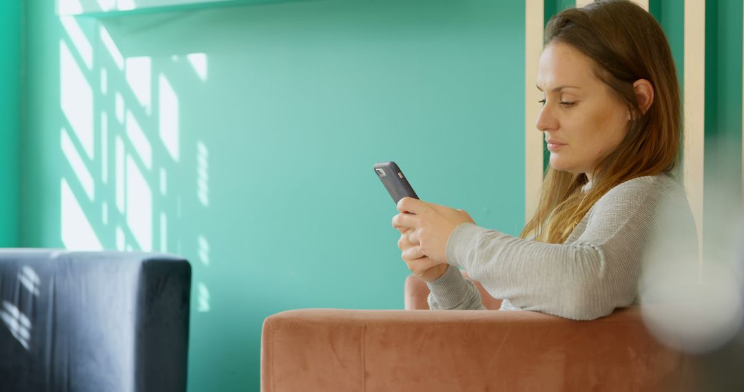 Woman Relaxing on Sofa Using Smartphone in Modern Interior - Free Images, Stock Photos and Pictures on Pikwizard.com