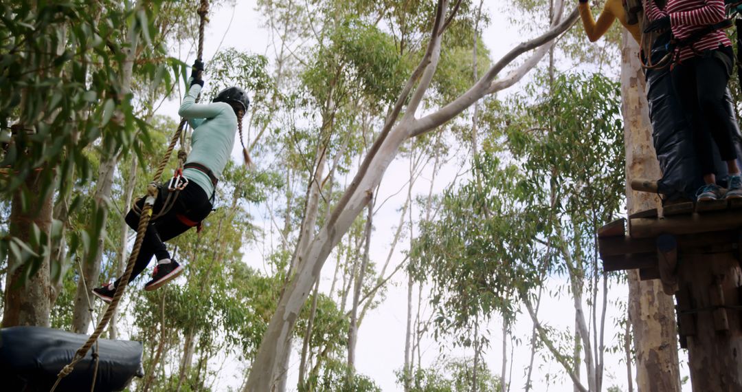 Adventure enthusiast zip-lining through lush forest