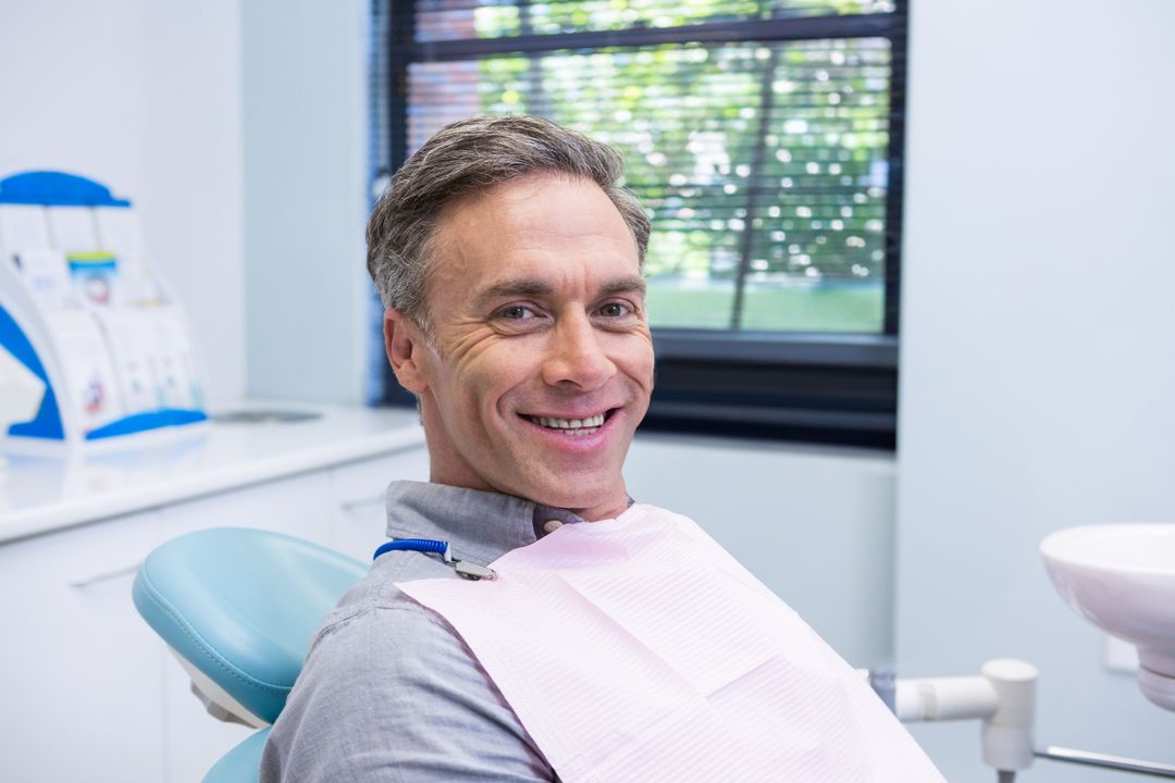 Smiling Middle-aged Man Relaxing in Dental Office for Checkup