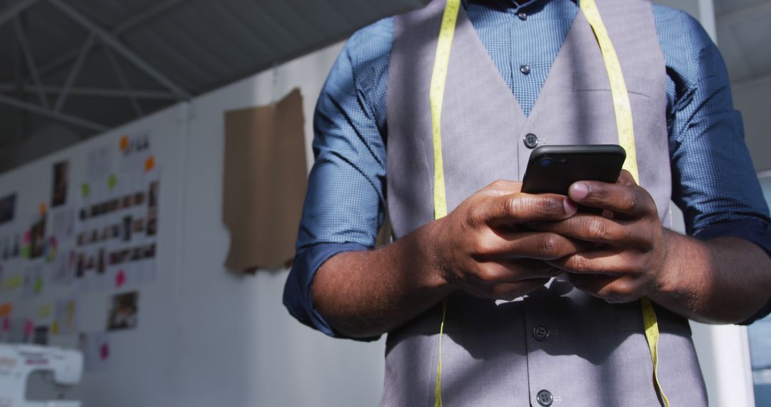 Fashion Designer Checking Smartphone in Creative Studio