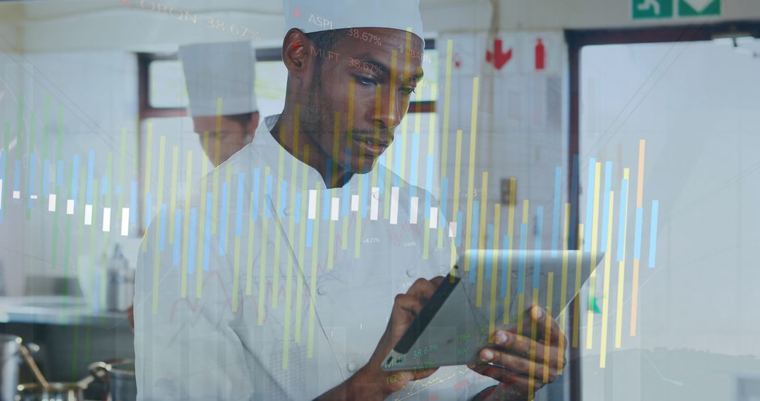 Chef Utilizing Tablet for Culinary Strategy in Modern Kitchen