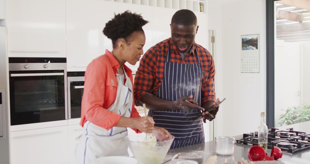 Image of happy african american couple baking together in kitchen - Free Images, Stock Photos and Pictures on Pikwizard.com