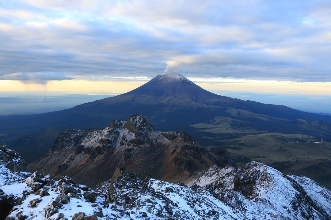 Stunning view of snow-capped volcanic mountain under clouded sky - Free Images, Stock Photos and Pictures on Pikwizard.com