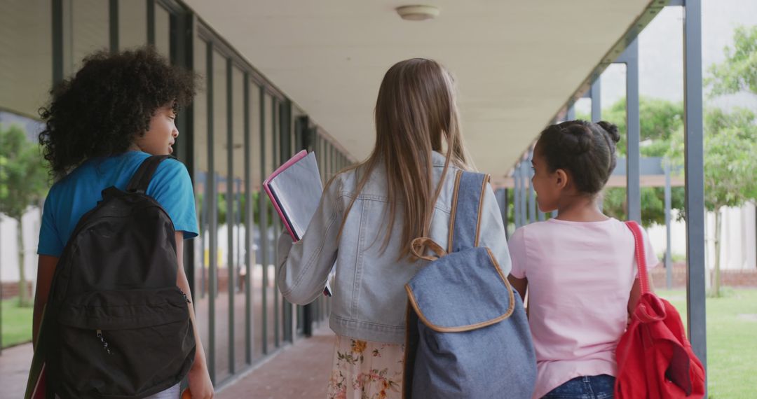 Back View of Schoolgirls Chatting in School Corridor