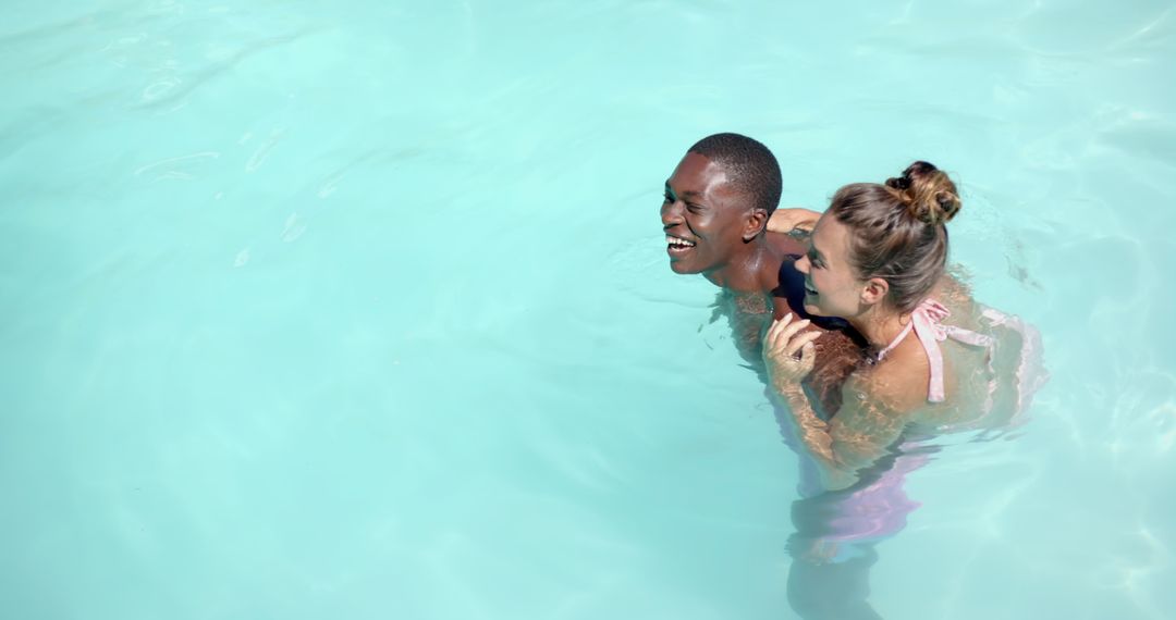 Joyful Diverse Couple Swimming Together in Bright Pool