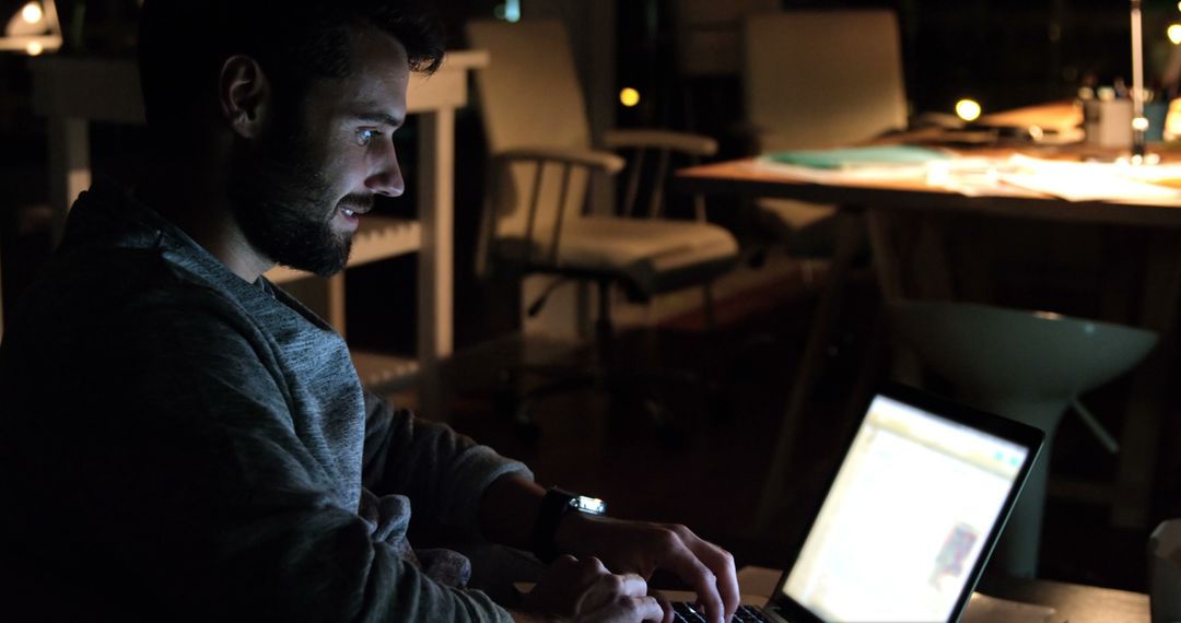 Man Working on Laptop Late at Night in Dimly Lit Room - Free Images, Stock Photos and Pictures on Pikwizard.com