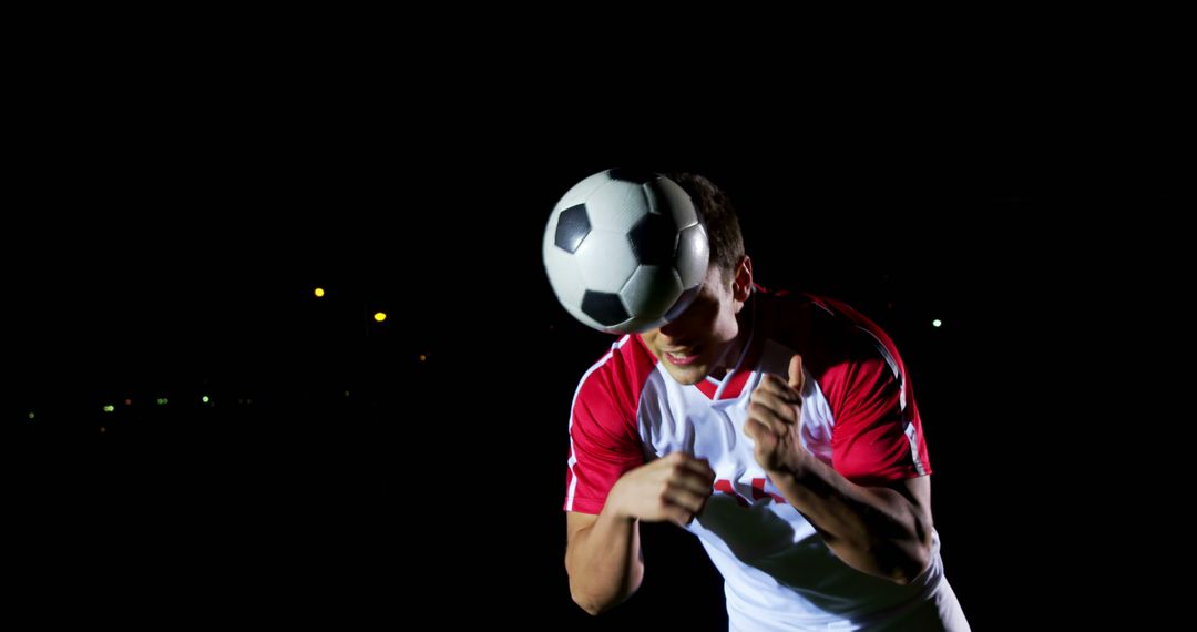 Soccer Player Heading Ball Under Stadium Lights at Night - Free Images, Stock Photos and Pictures on Pikwizard.com