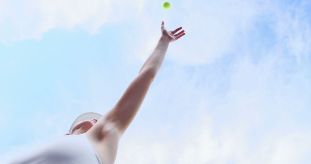 Tennis Player Serving Ball Under Clear Blue Sky - Free Images, Stock Photos and Pictures on Pikwizard.com