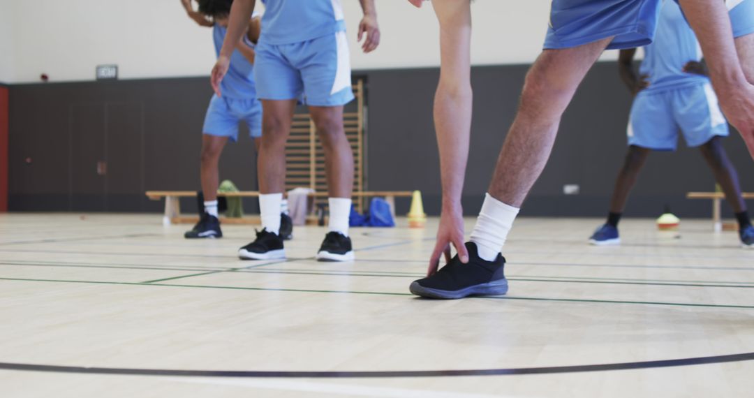 Diverse Basketball Team Stretching on Indoor Court