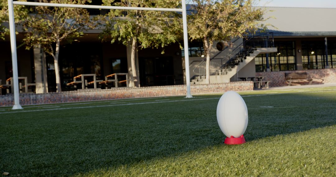 Rugby Ball on Tee on Green Turf Field Under Sunshine