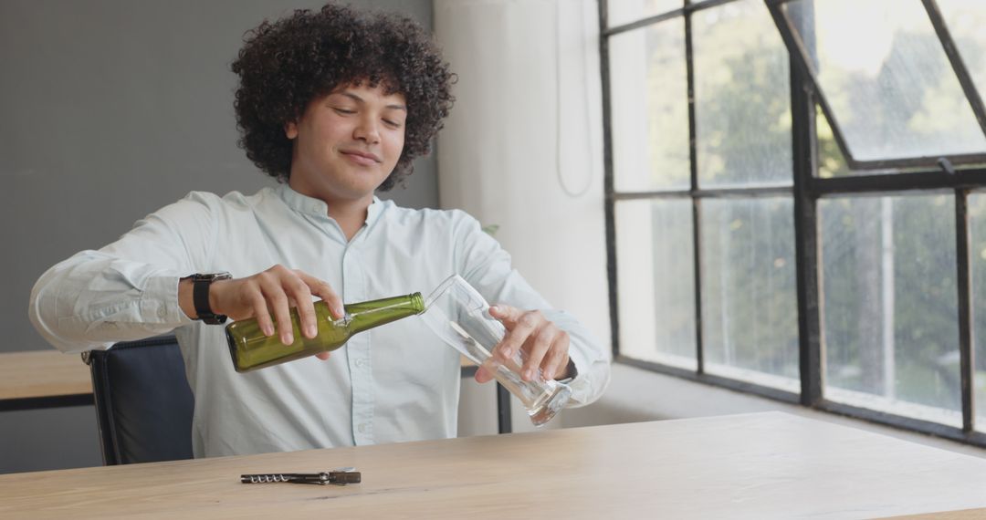 Man Enjoying Refreshing Beverage at Work Desk During Break