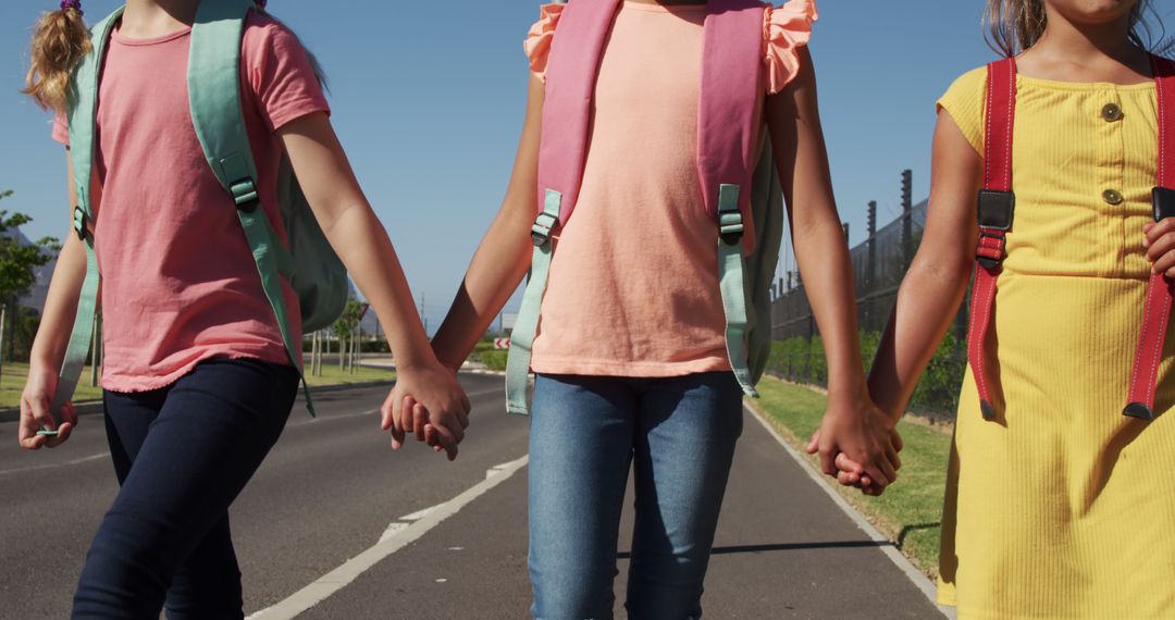 Young girls holding hands while walking on sunny day - Free Images, Stock Photos and Pictures on Pikwizard.com