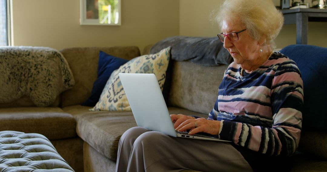 Senior Woman Using Laptop on Sofa at Home - Free Images, Stock Photos and Pictures on Pikwizard.com