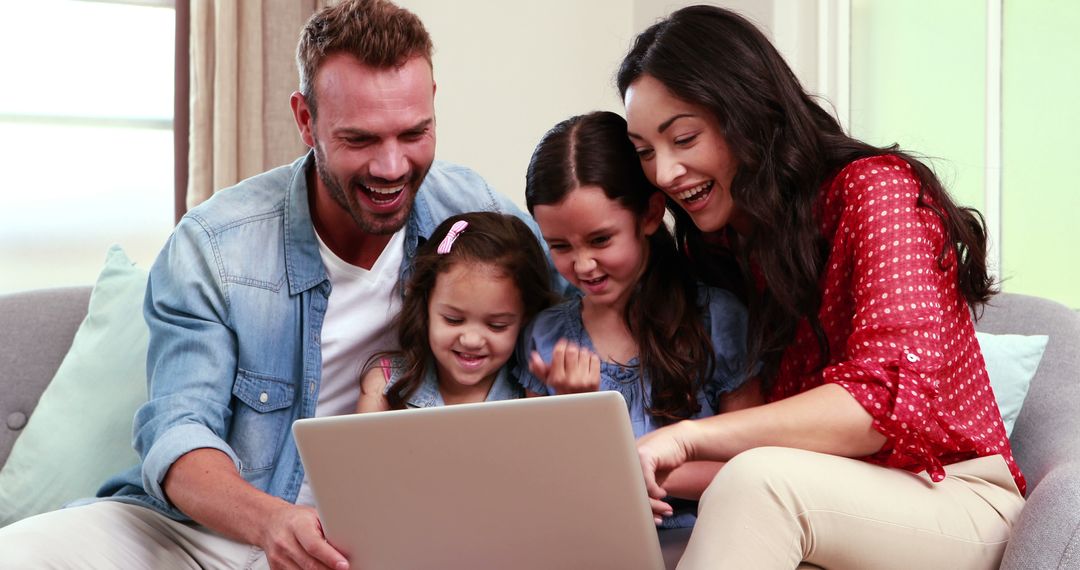Happy Family Browsing Laptop on Sofa at Home