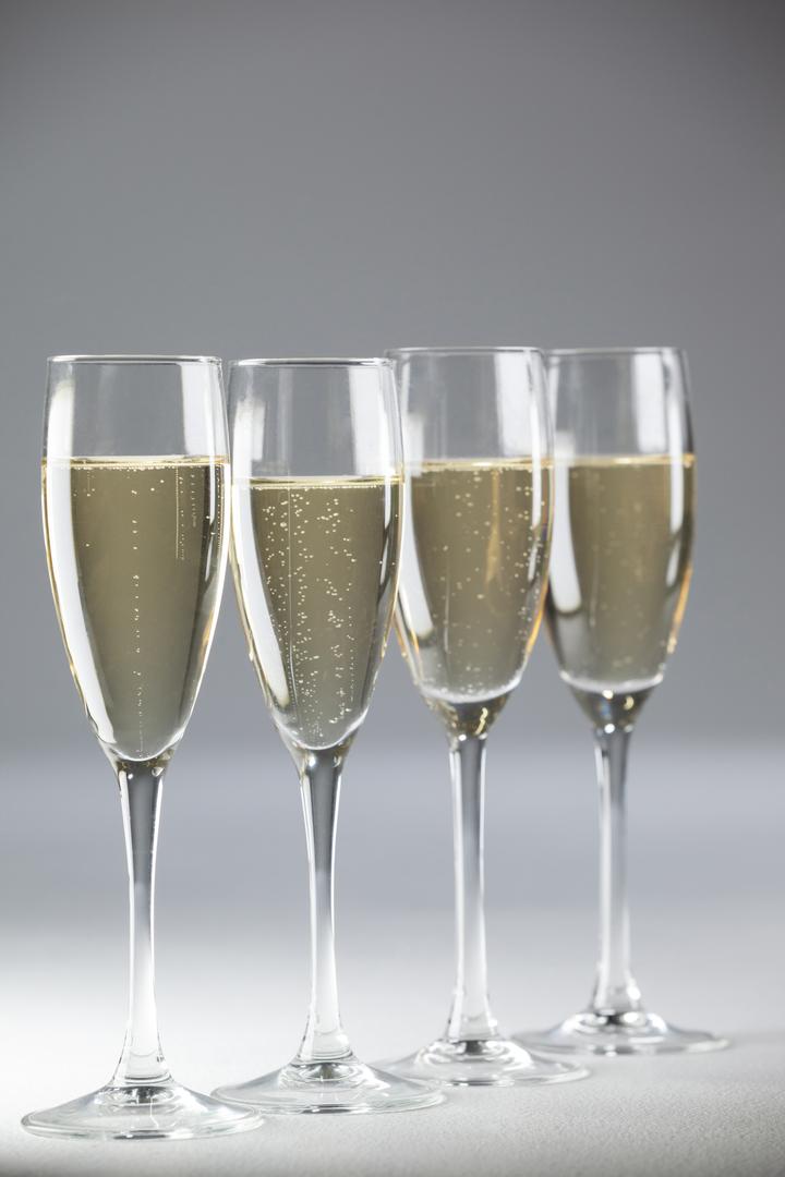 Four champagne flutes on white background - Free Images, Stock Photos and Pictures on Pikwizard.com