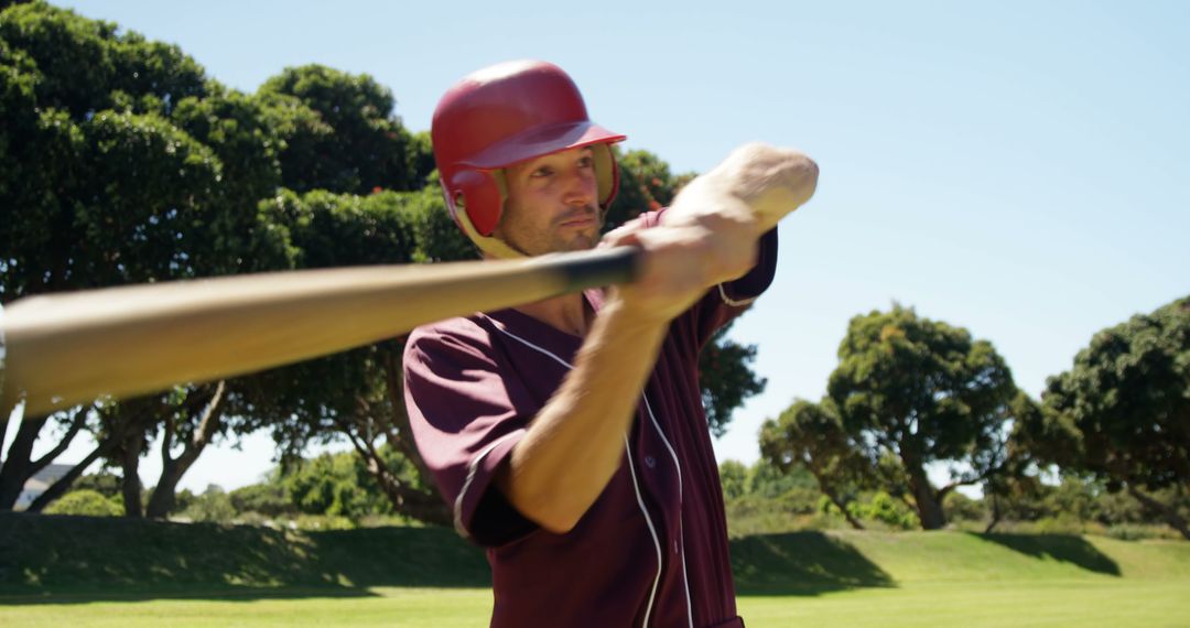 Focused Baseball Player Swinging Bat in Outdoor Practice