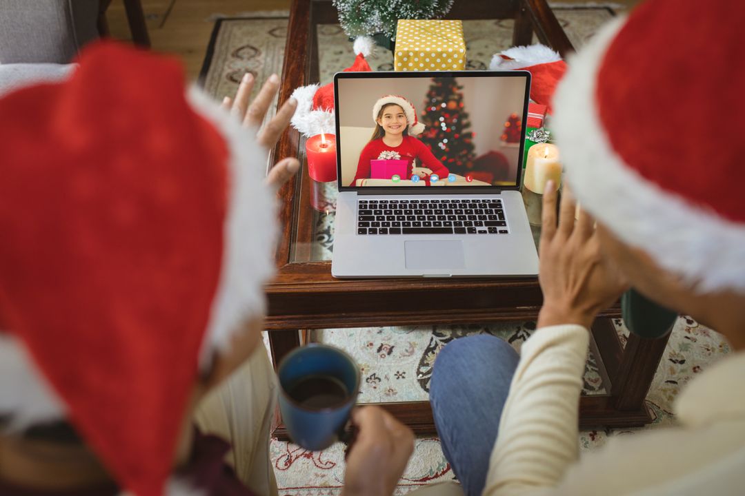 Diverse Couple in Santa Hats Having Christmas Video Call with Happy Child on Laptop - Free Images, Stock Photos and Pictures on Pikwizard.com