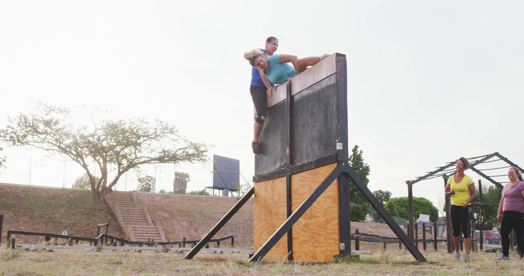 Group of Athletes Climbing Over Obstacle Wall in Outdoor Training - Free Images, Stock Photos and Pictures on Pikwizard.com