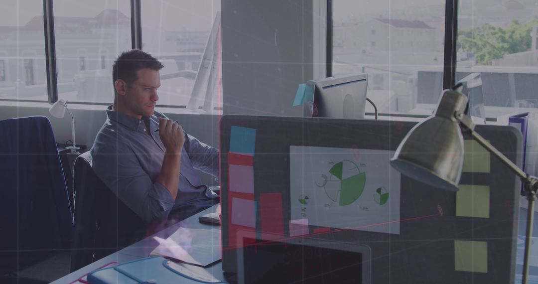 Focused Businessman Analyzing Data on Laptop in Modern Office