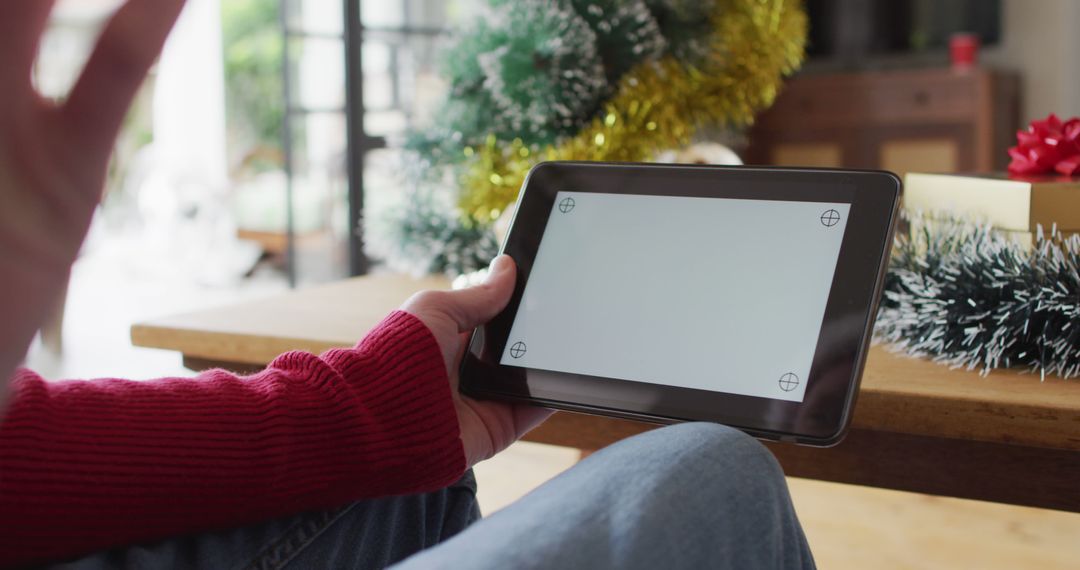 Person Watching Video on Tablet During Holiday Season - Free Images, Stock Photos and Pictures on Pikwizard.com