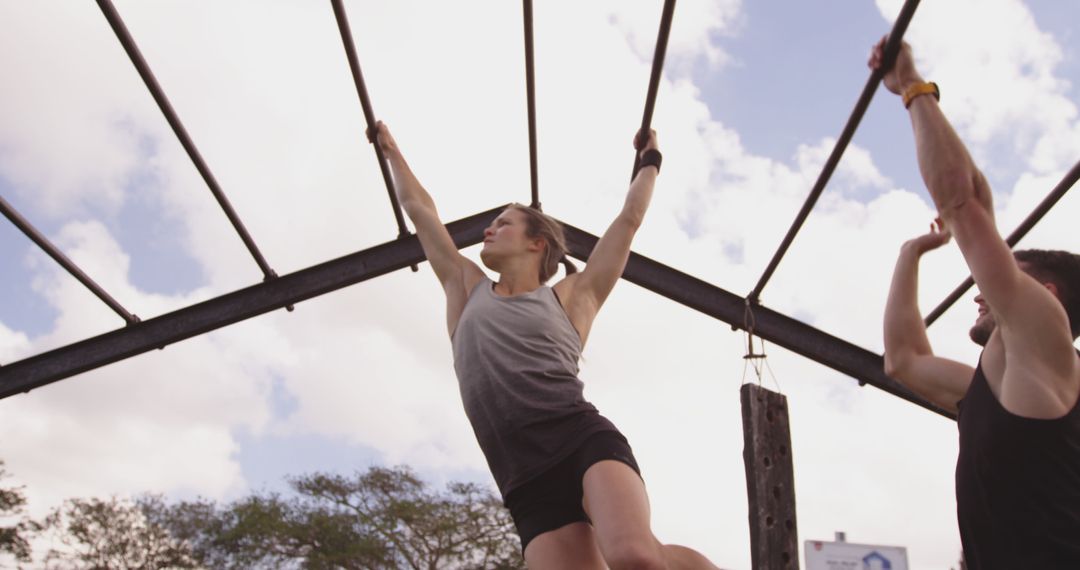 Man and Woman Exercising on Outdoor Monkey Bars - Free Images, Stock Photos and Pictures on Pikwizard.com