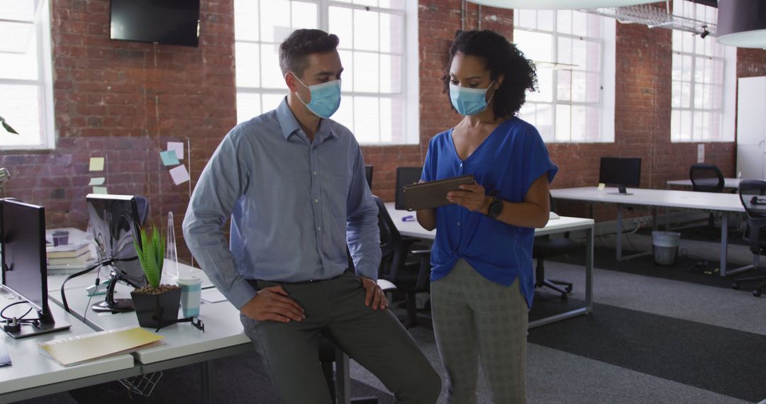 Colleagues Collaborating While Wearing Face Masks in Modern Workspace - Free Images, Stock Photos and Pictures on Pikwizard.com