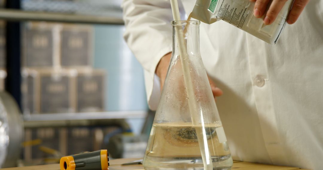 Scientist Pouring Liquid into Flask in Laboratory Setting - Free Images, Stock Photos and Pictures on Pikwizard.com