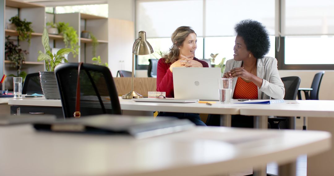 Two Businesswomen Having a Discussion at Office Desk - Free Images, Stock Photos and Pictures on Pikwizard.com