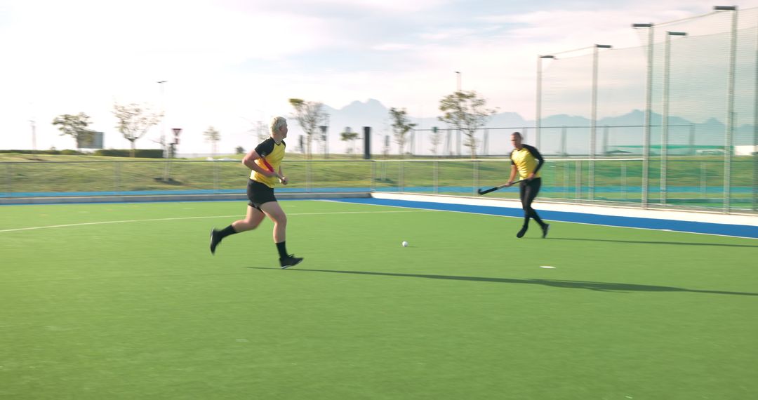 Teammates Running with Hockey Sticks on Turf