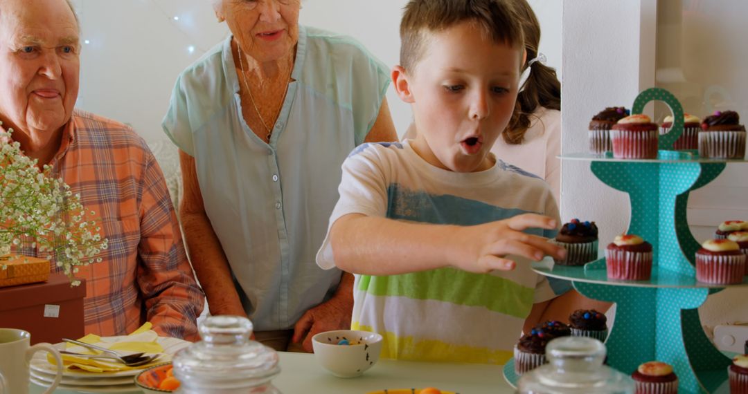 Young Boy Selecting Cupcake at Family Gathering - Free Images, Stock Photos and Pictures on Pikwizard.com