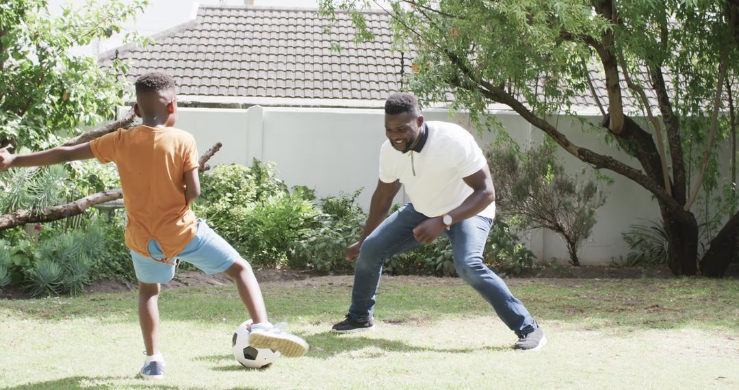 Father and Son Playing Soccer in Sunny Backyard Enjoying Leisure Time
