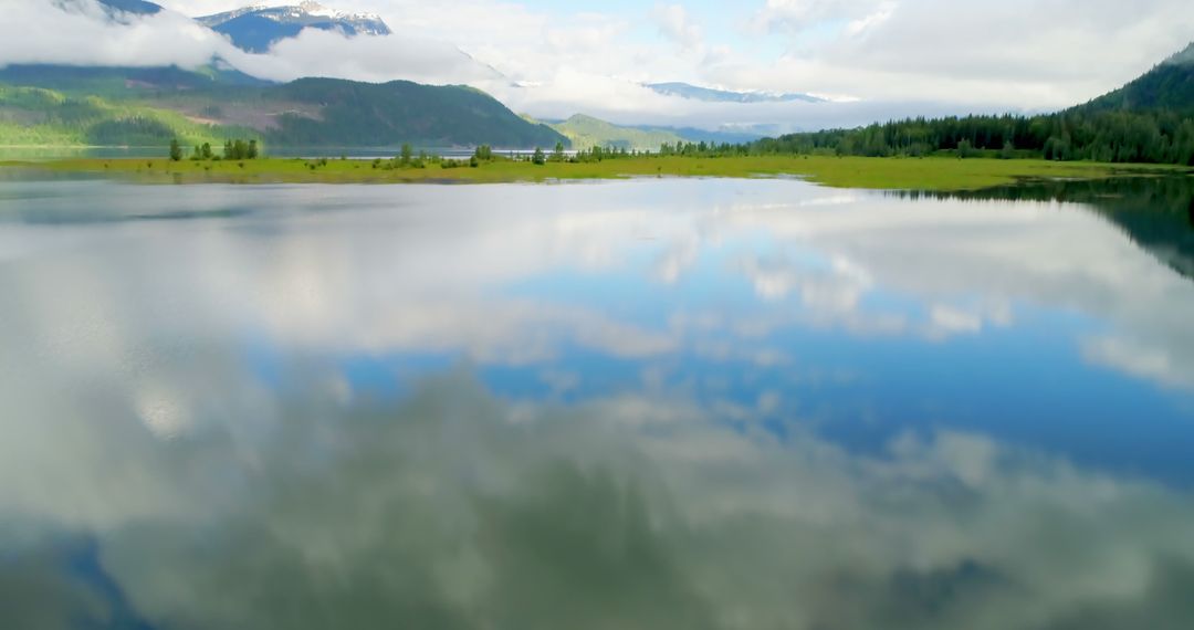 Serene Mountain Lake with Reflective Water and Cloudy Sky - Free Images, Stock Photos and Pictures on Pikwizard.com