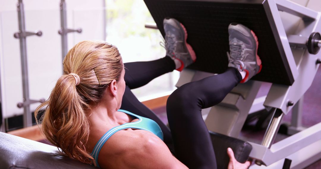 Woman performing leg press exercise in gym - Free Images, Stock Photos and Pictures on Pikwizard.com