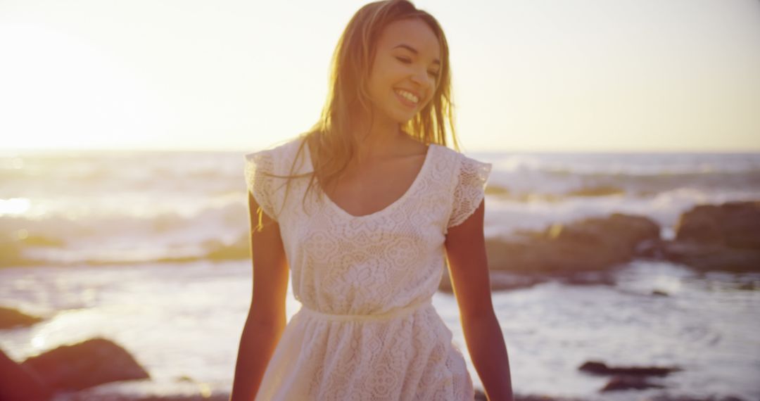 Smiling Young Woman at Sunset on Beach - Free Images, Stock Photos and Pictures on Pikwizard.com