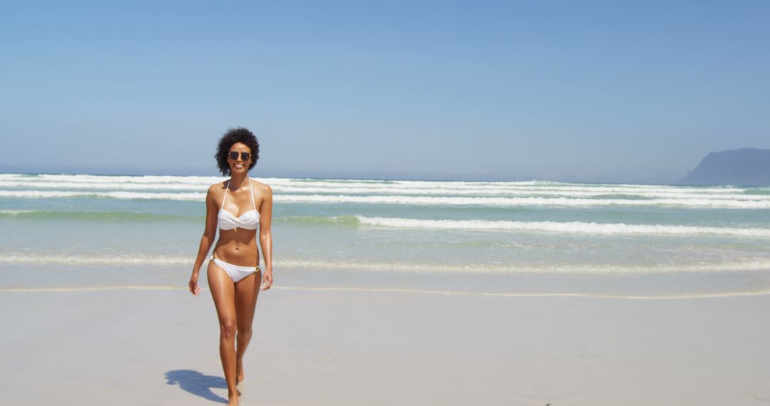 Woman in White Bikini Walking on Sunny Beach - Free Images, Stock Photos and Pictures on Pikwizard.com